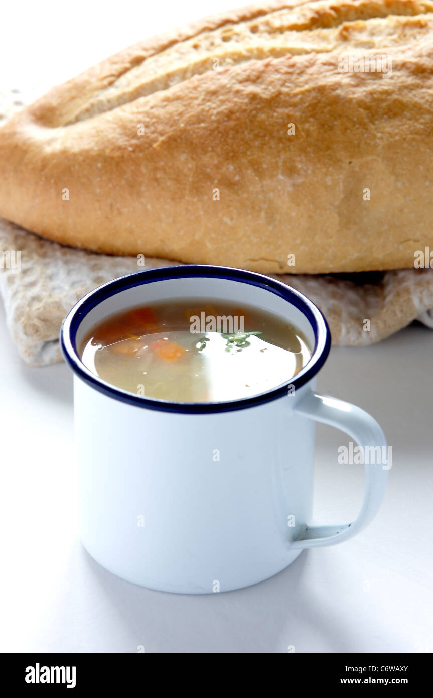 Emaille Becher mit Huhn und Gemüse Suppe und eine französische Bauerngewerkschaft Laib Stockfoto