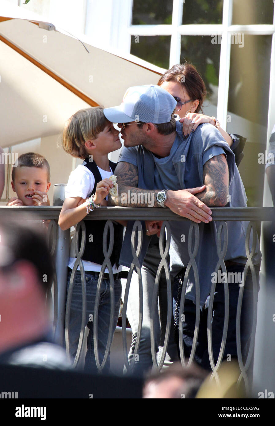 David Beckham küsst seinen Sohn Romeo Beckham, während gerade die Jonas Brothers in The Grove von einem Balkon Los Angeles durchführen, Stockfoto