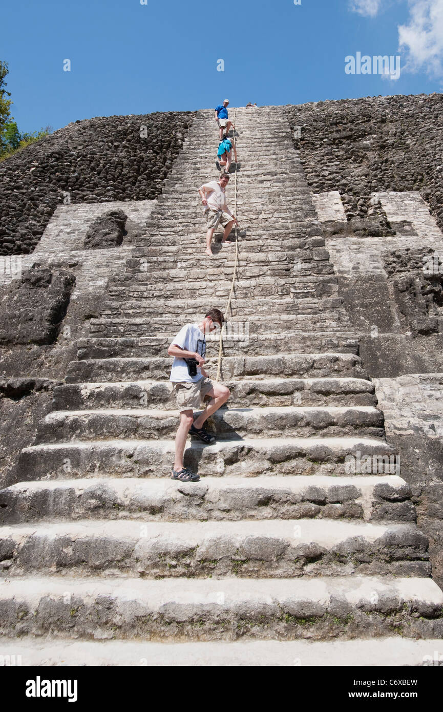Touristen Klettern hoch Tempel von Lamanai, Belize mit einem Seil-Hilfe. Stockfoto