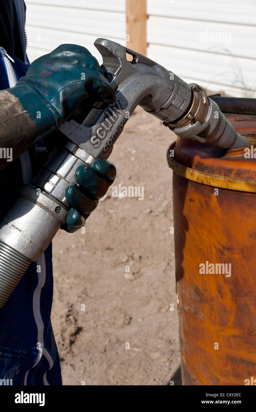 Mann Füllung Fass mit Automobil Gasöl Stockfoto