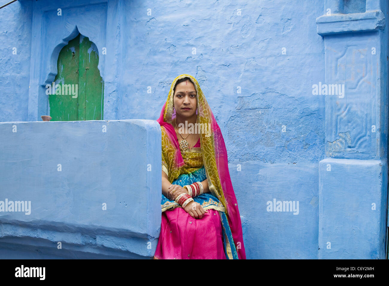 Eine Frau von Jodhpur, Indien Rajasthan Zustand in traditioneller Kleidung vor beherbergt eines der Stadt berühmte blau Stockfoto