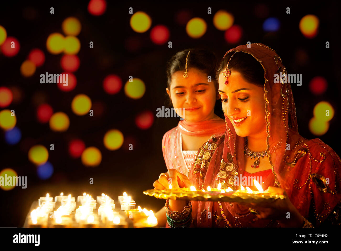 Mutter ein Tablett mit Diyas zu halten, während ihre Tochter blickt auf Stockfoto
