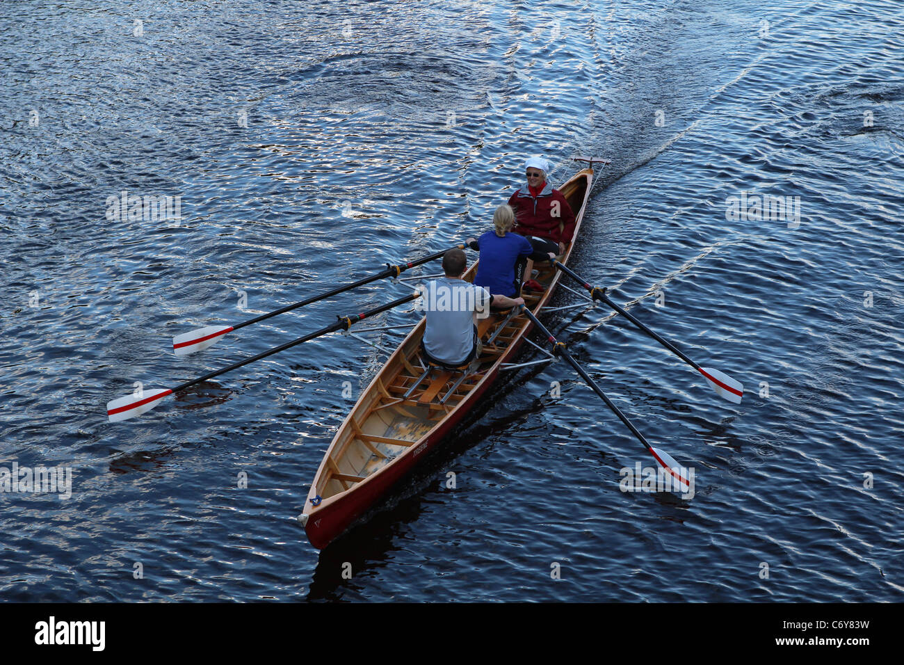 Drei Personen in einem Ruderboot auf einem Kanal in Hamburg Stockfoto