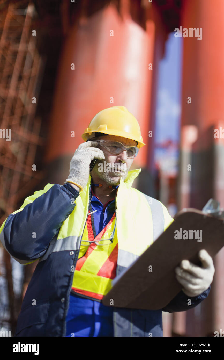Arbeiter reden über Handy auf Bohrinsel Stockfoto