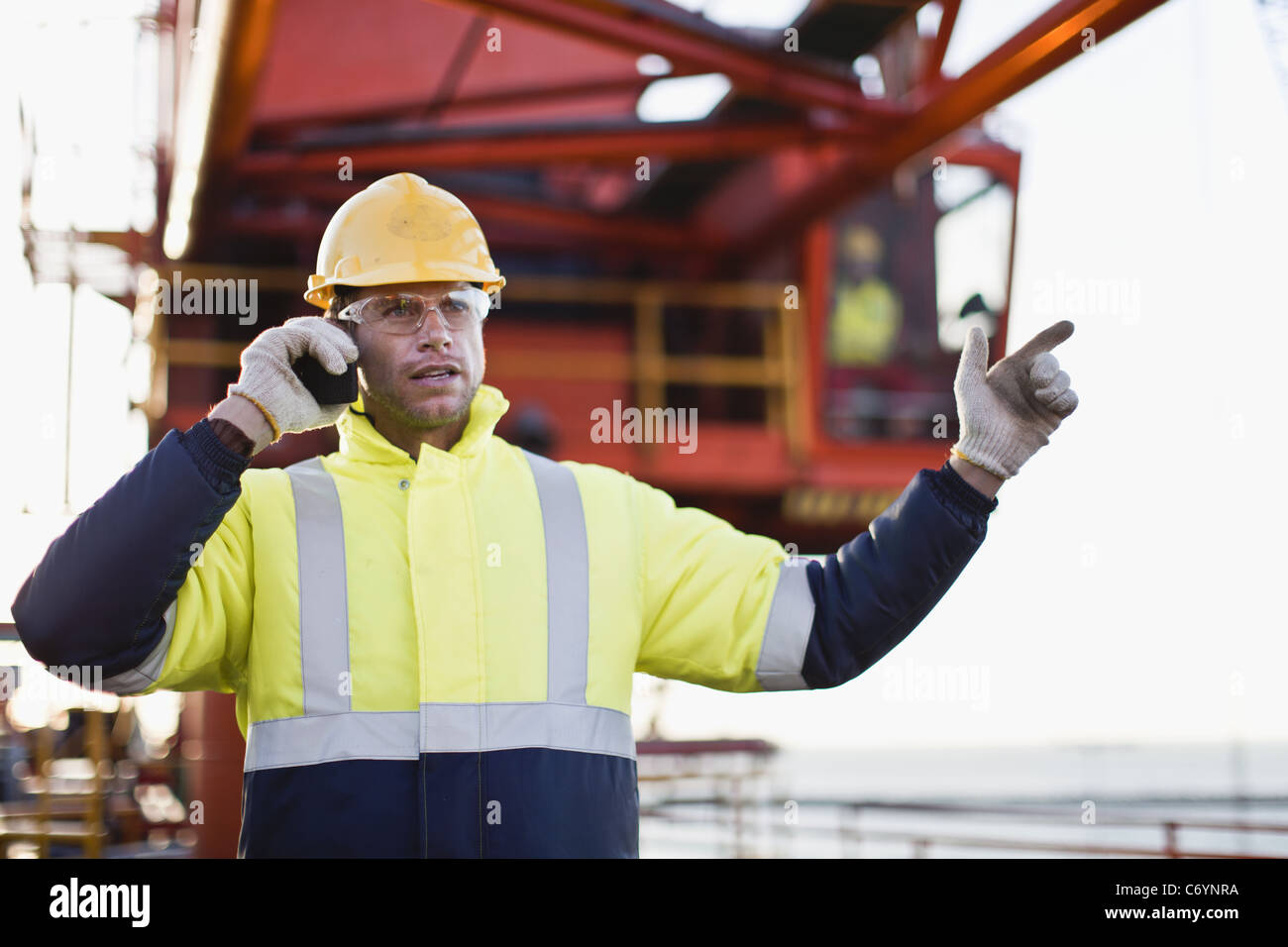 Arbeiter mit Walkie-Talkie auf Bohrinsel Stockfoto
