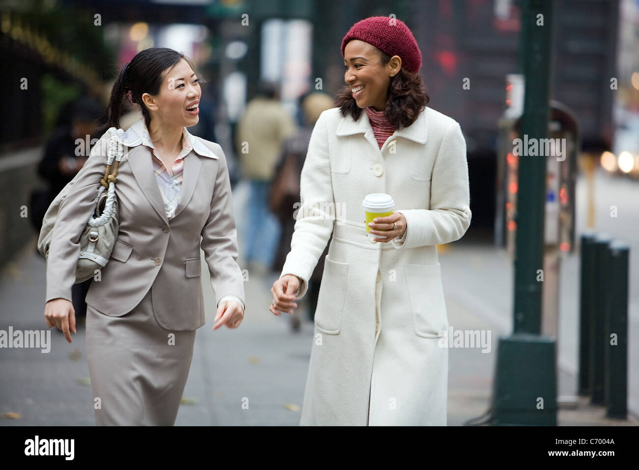 Zwei Business-Frauen ein Gespräch während des Gehens in der Großstadt. Stockfoto
