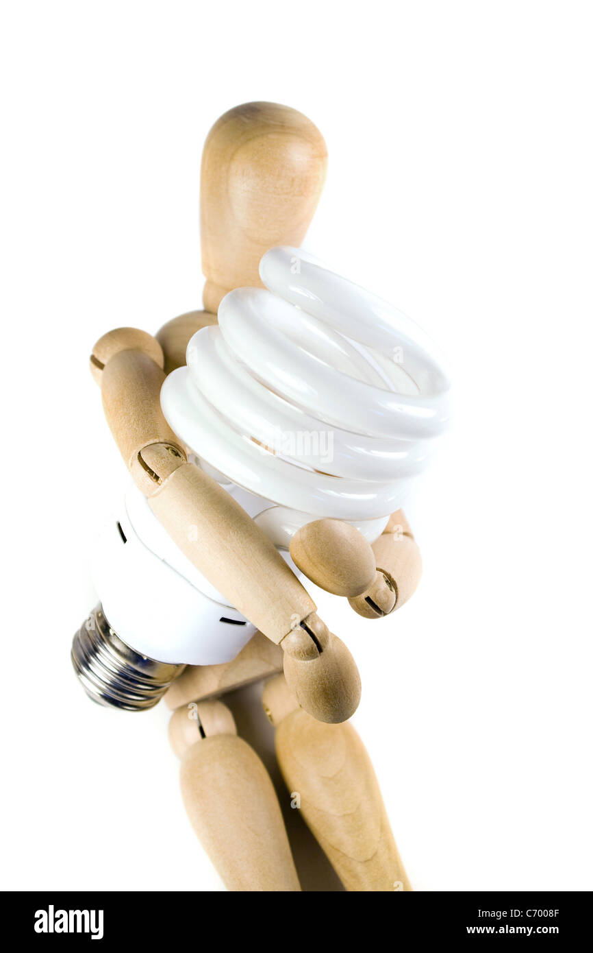 Ein Holzmodell greifen eine kompakte Leuchtstoff Glühlampe. Ideal für Energieeinsparungen oder grüne Konzepte. Stockfoto