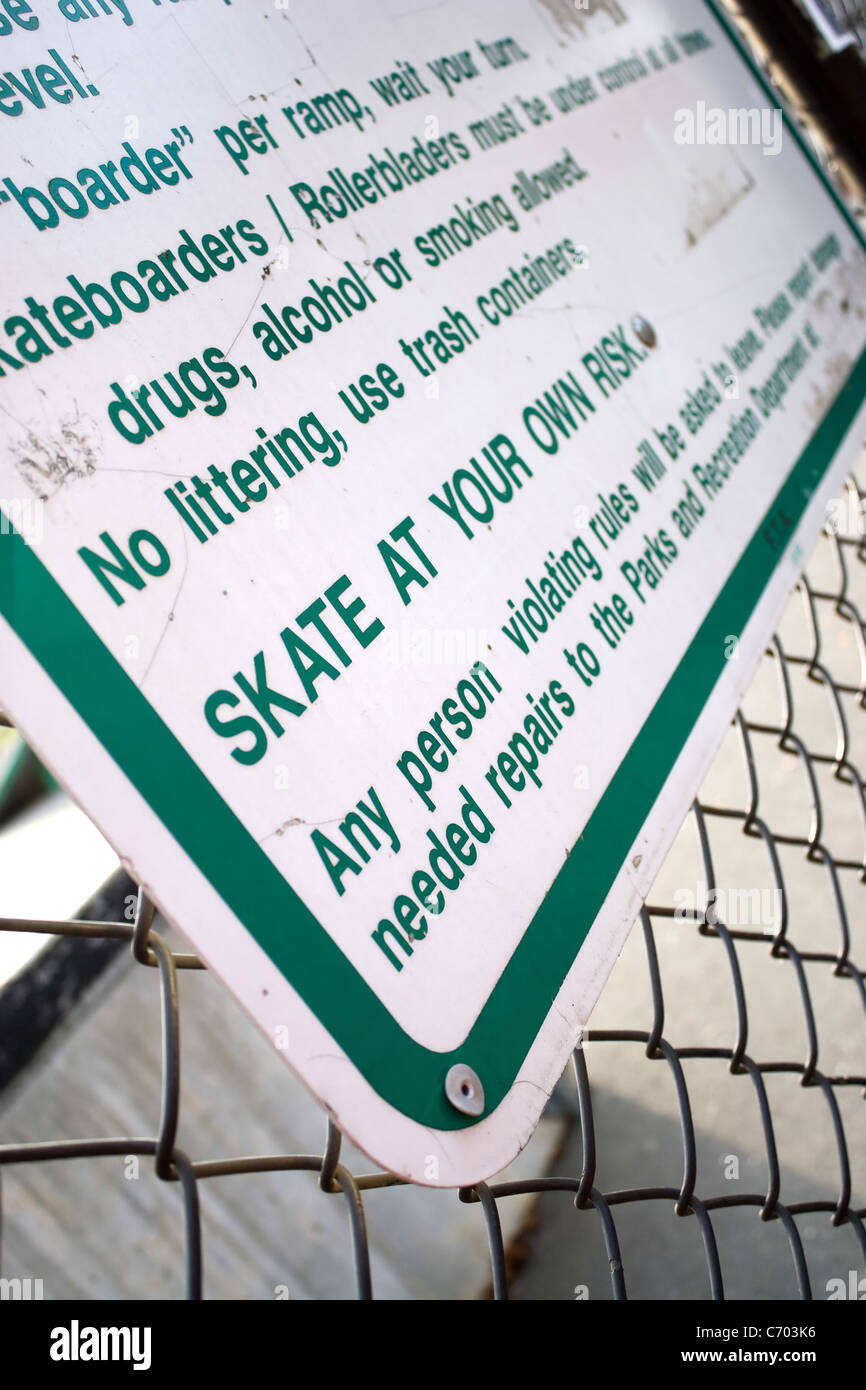 Ein Schild an der Skate-Park stellt klar, dass man auf Ihr eigenes Risiko Schlittschuh laufen werden. Geringe Schärfentiefe. Stockfoto