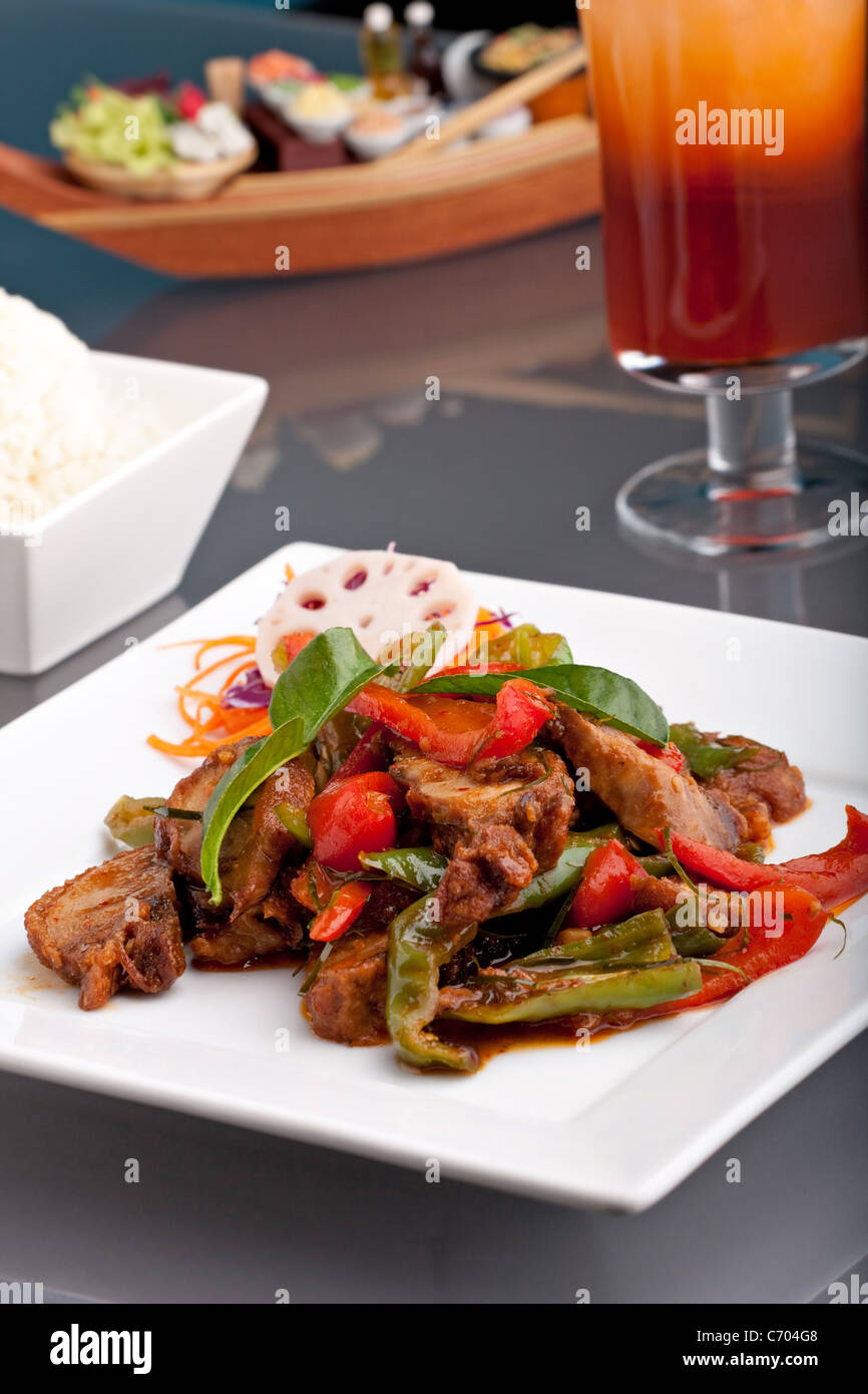 Ein frisches Gericht der Thai-Stil Chile Basilikum Ente mit gemischtem Gemüse weiße klebrige Jasminreis und thai Eistee. Stockfoto