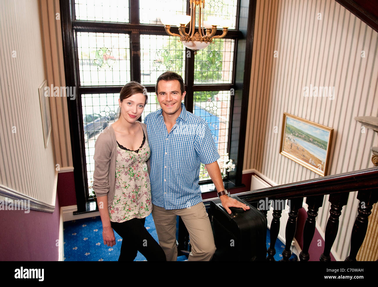 Paar steht auf Treppen im Haus Stockfoto