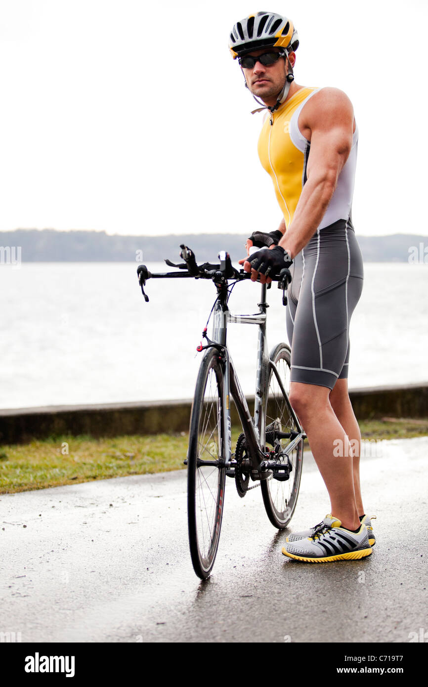 Ein Triathlet steht in der Nähe von seinem Fahrrad. Stockfoto