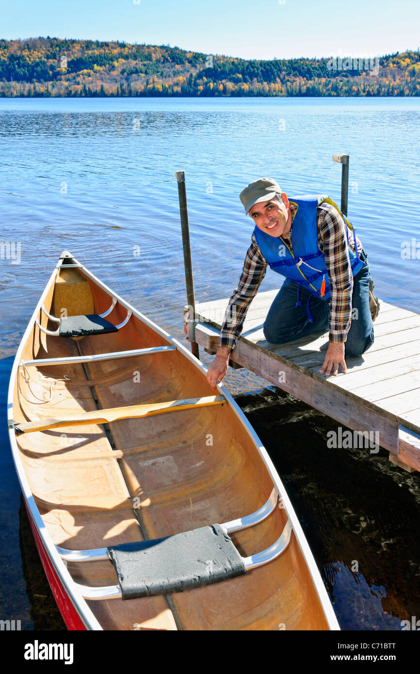 Mann hält Kanu am Dock am Lake of Two Rivers, Ontario, Kanada Stockfoto