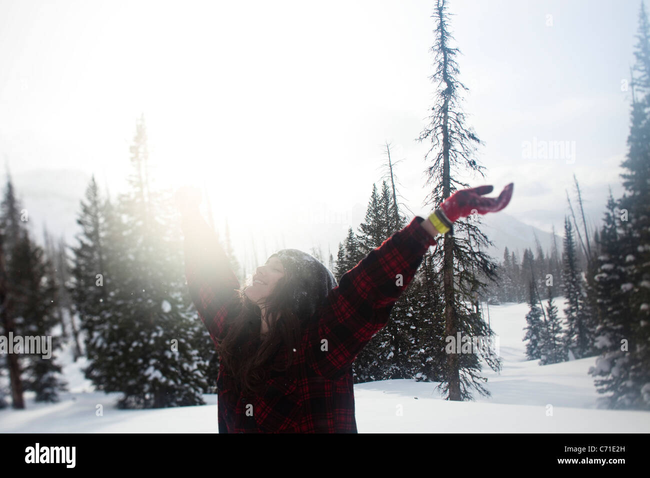 Eine schöne Frauen Lächeln beim Wandern durch unberührte Schneefeld bei Sonnenuntergang in Wyoming. Stockfoto