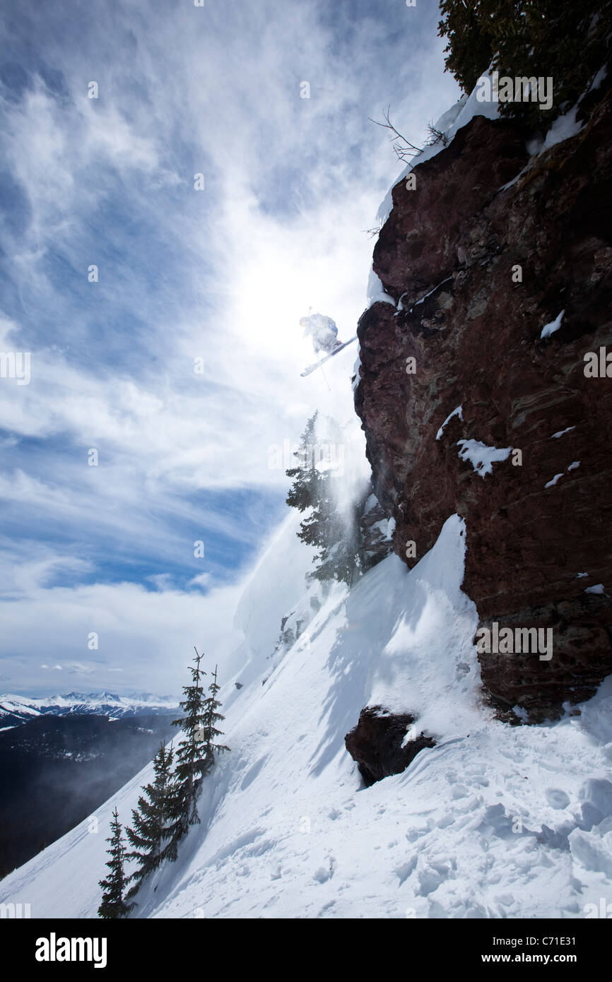Ein männlicher Skifahrer springt von einer Klippe an einem sonnigen Tag in Colorado. Stockfoto
