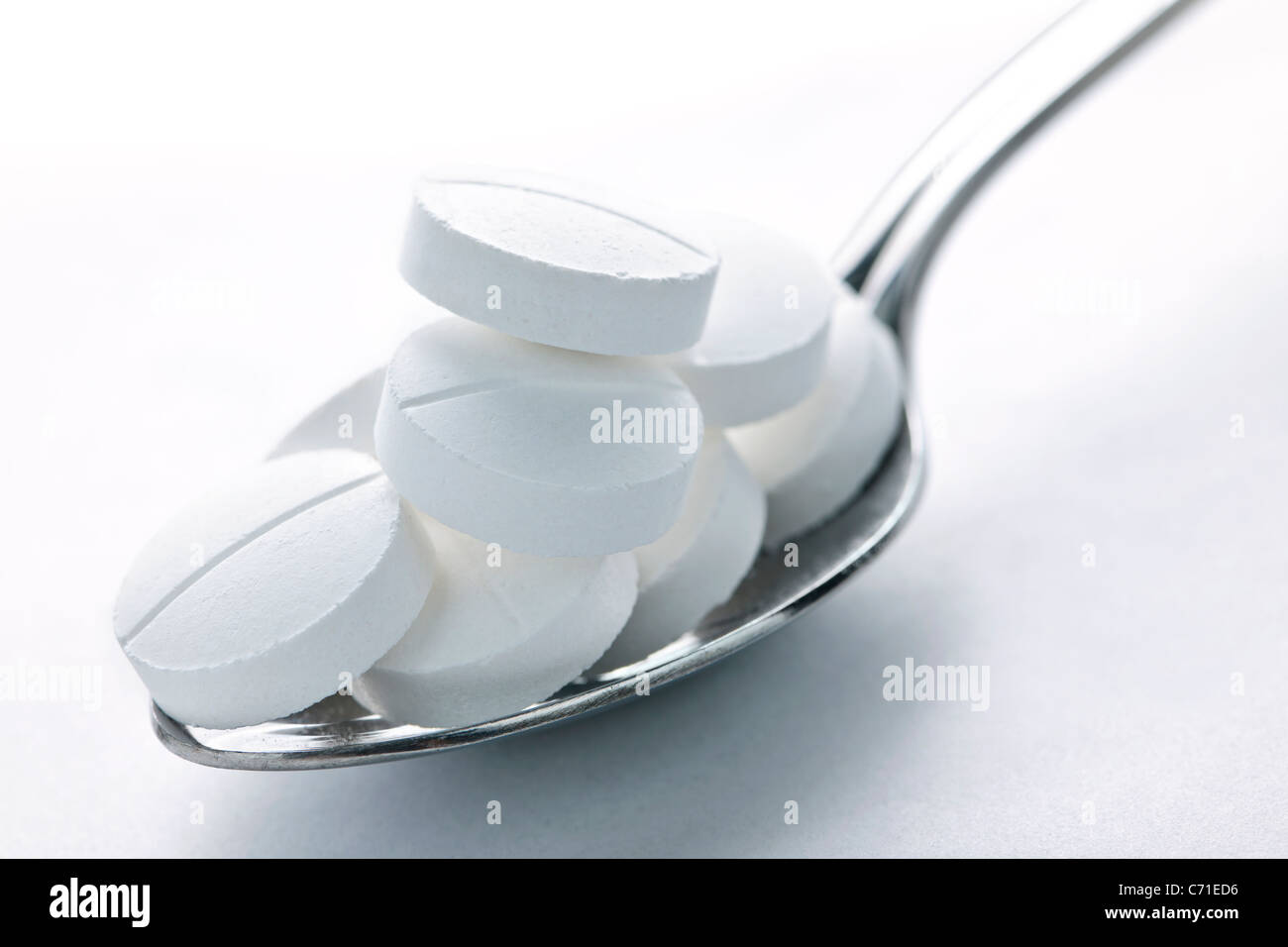 Calcium Supplement Pillen gestapelt auf Metalllöffel closeup Stockfoto