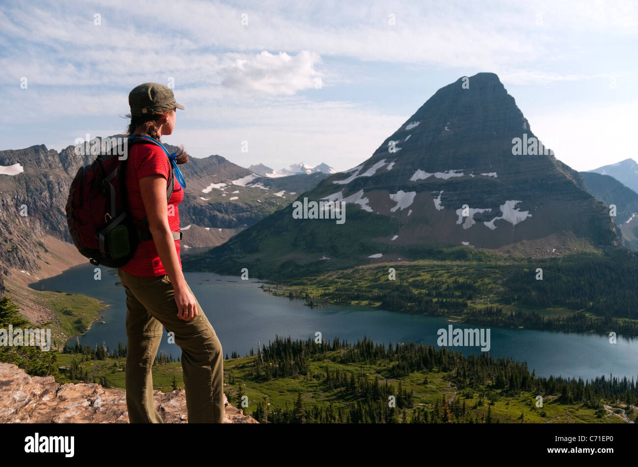 Eine junge weibliche Wanderer blickt auf verborgenen See und Bear Hut Mountain im Glacier National Park, Montana. Stockfoto