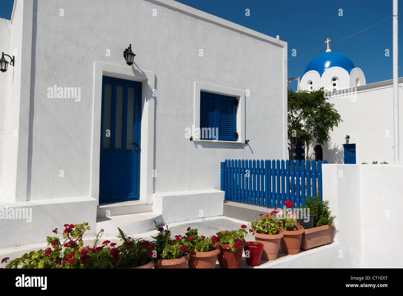 Blaue Kuppel griechische Kirche und weißen Mauern umgebene Haus im Dorf Akrotiri, Santorin, Griechenland Stockfoto