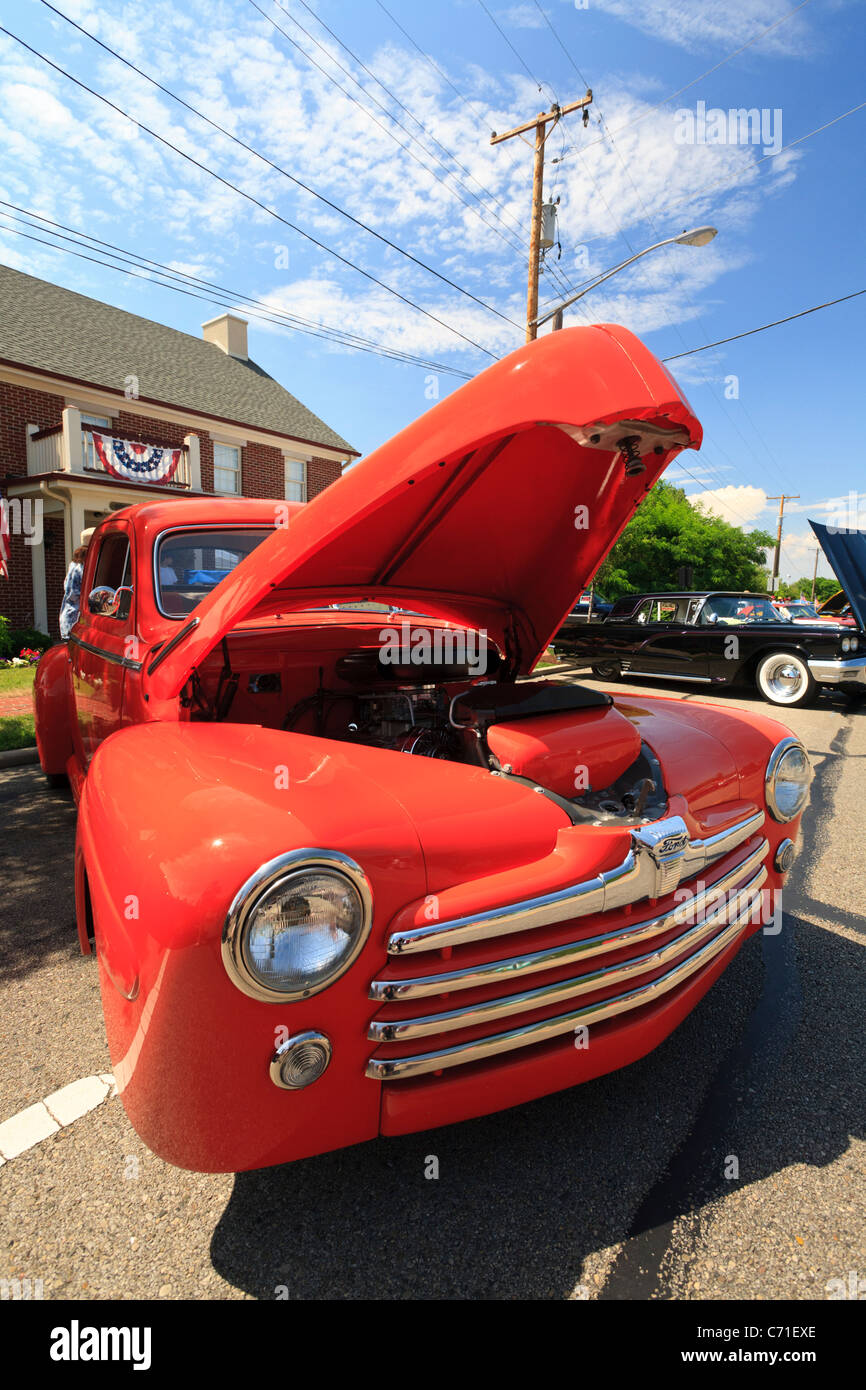 Restaurierte Oldtimer in leuchtend orange Farbe und Motorhaube geöffnet. Stockfoto