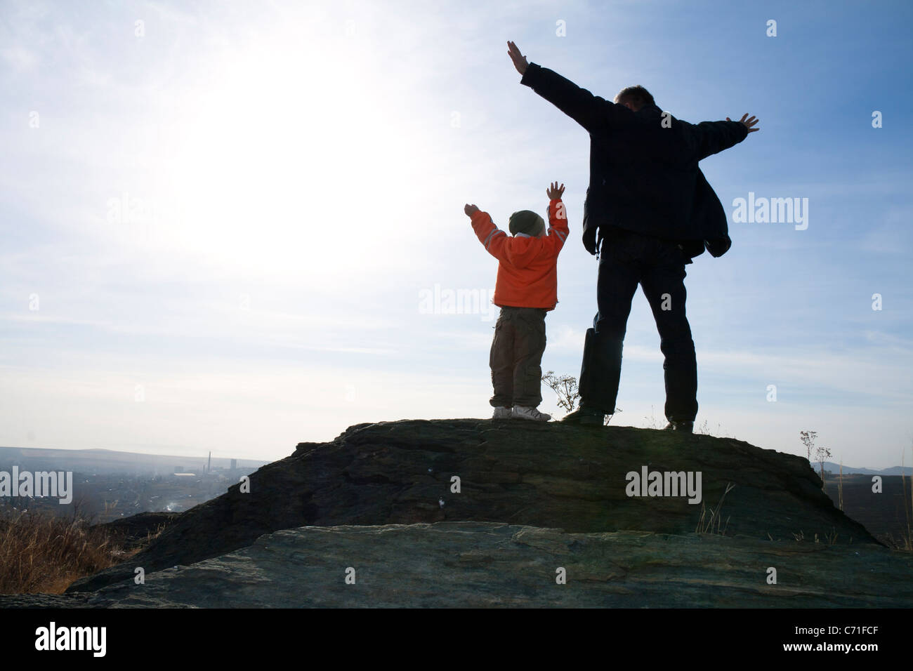 Mit dem Ausdruck ihrer Vater und Sohn stehen auf dem Stein, die Arme zum Himmel erhoben. Stockfoto