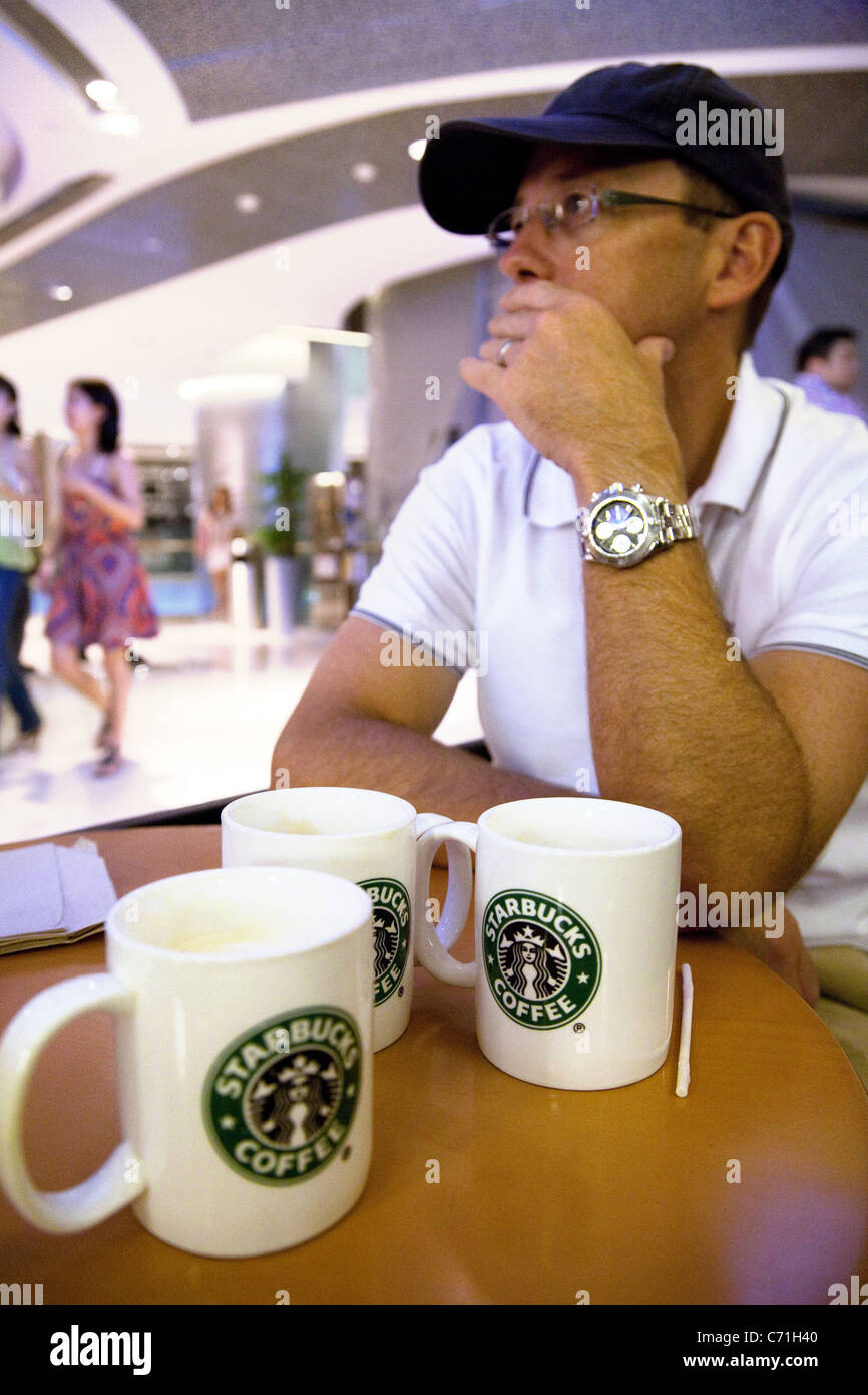 Ein Mann sitzt im Starbucks, Singapur Asien Stockfoto