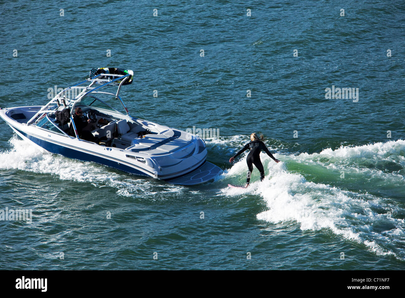 Eine glückliche athletische Frau wake surft hinter einem Wakeboard-Boot in Idaho. Stockfoto