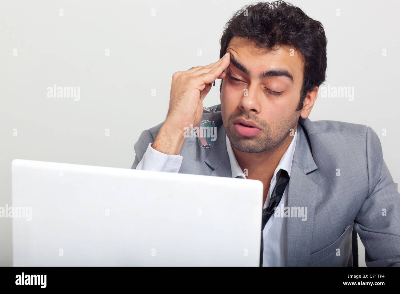 Geschäftsmann am Arbeitsplatz schläfrig fühlen Stockfoto
