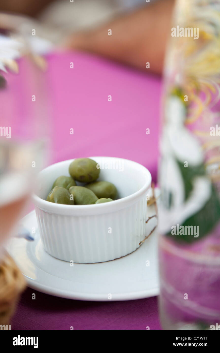Grüne Oliven in Töpfchen auf Picknick-Tisch im freien Stockfoto
