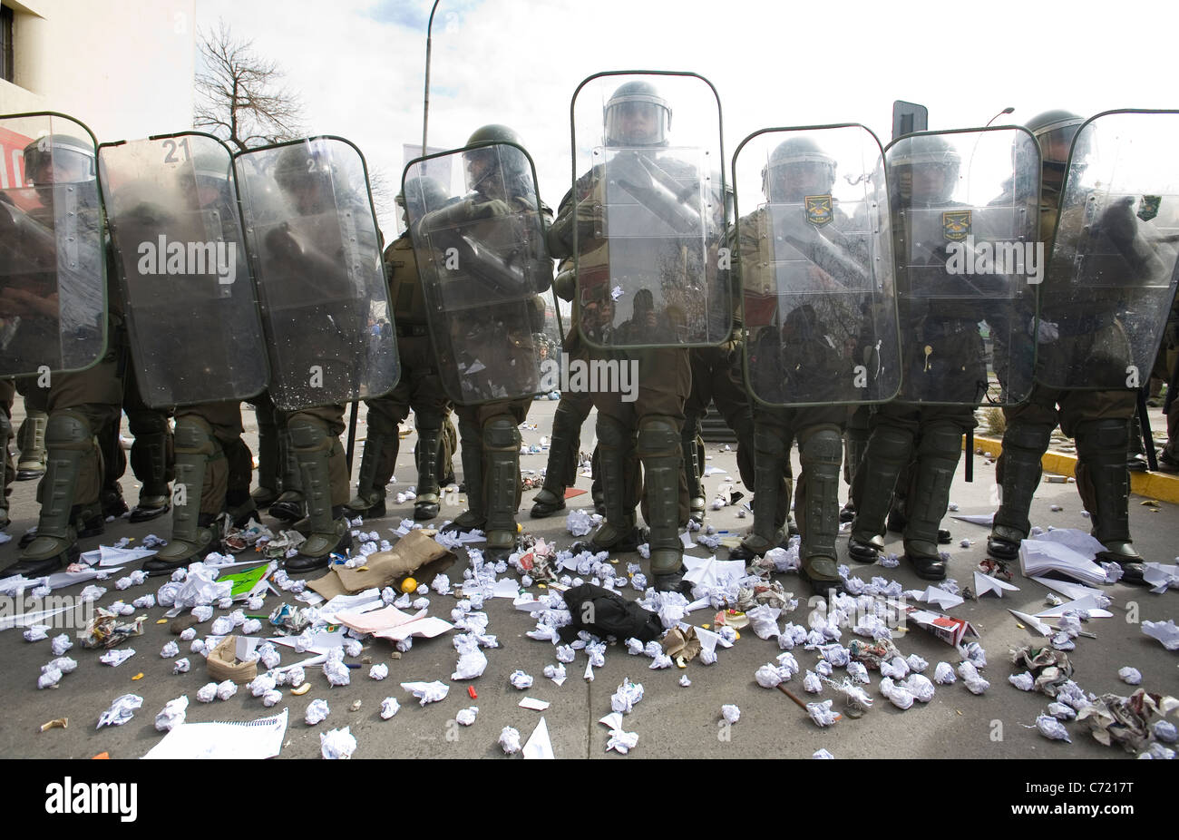 Linie der chilenischen Polizei in voller anti-Kampfausrüstung Papierkugeln erhalten Studenten protestieren in Santiago de Chile Stockfoto