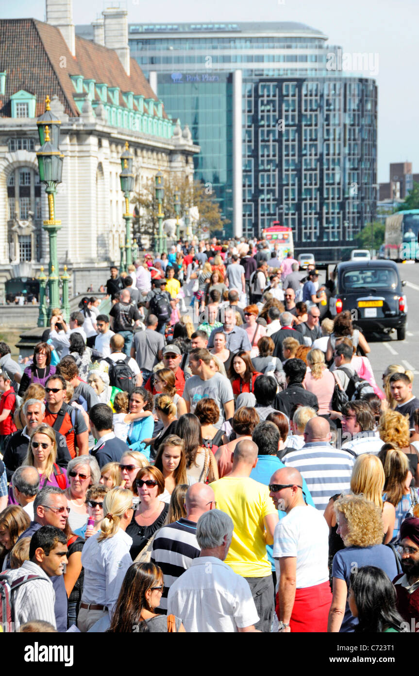 Masse der Leute auf die London Street Sommer Blick von oben nach unten schaut auf Massen von Touristen zu Fuß entlang der Fahrbahn in Westminster Bridge GROSSBRITANNIEN Stockfoto