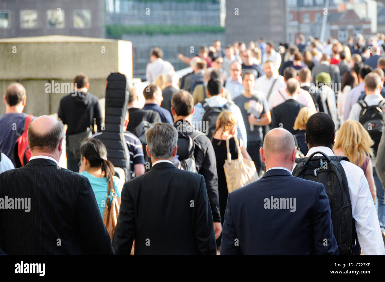 London Bridge Rückansicht Nahaufnahme drei Männer in Anzügen zwei kahlköpfige Büroangestellte gehen zur London Bridge Station während der abendlichen Hauptverkehrszeit England Großbritannien Stockfoto