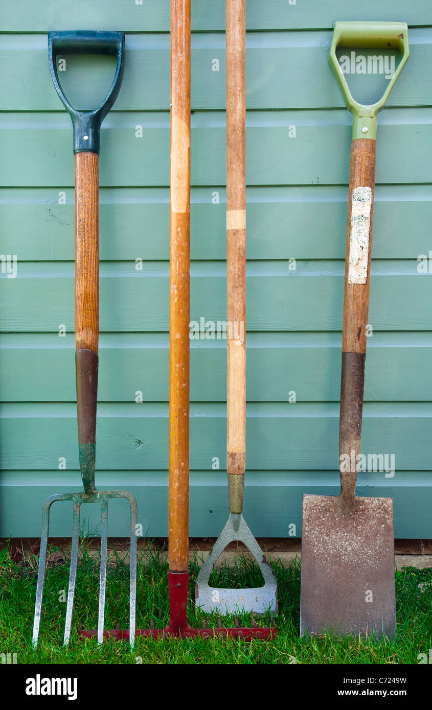Garten / Gartenarbeit Werkzeuge lehnt sich an die Seite der ein Gartenhaus - einschließlich einer Gabel, Rechen, Hacke und Spaten verwendet. Stockfoto