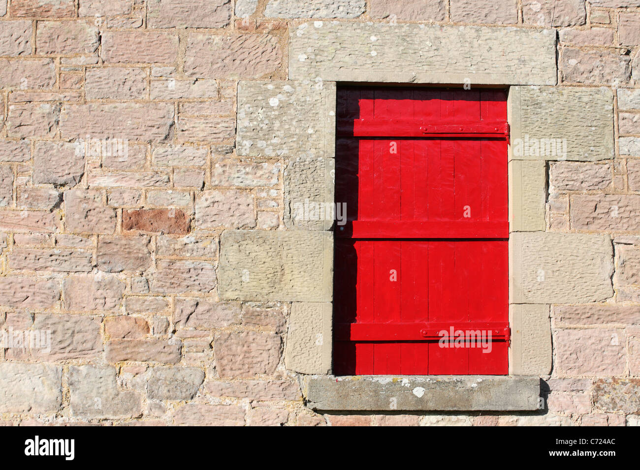 Roten Fensterläden Fenster gegen Rosa schottischem Granit Wand, neben dem Fluss Tweed, Fishwick, Grenzen, Schottland Stockfoto