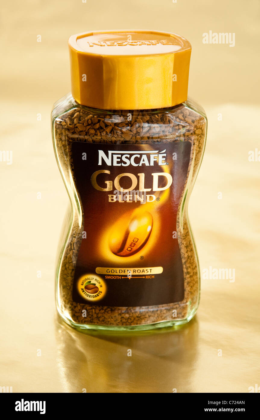 Nescafe Gold Blend Instantkaffee jar auf einem weichen goldenen Hintergrund. Stockfoto