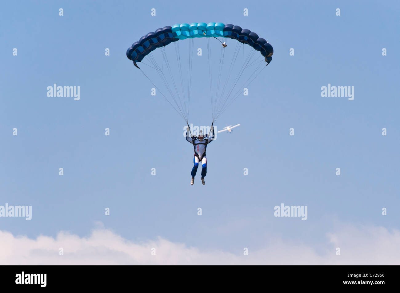 Ein Paracute Jumper Fallschirmspringen mit Flugzeug hinter ihm in der Ferne am Ellough Flugplatz in der Nähe von Beccles in Suffolk, England, Vereinigtes Königreich Stockfoto