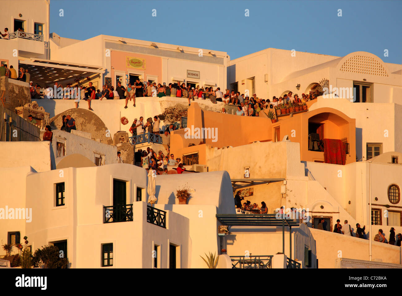 Hunderte von "Sonnenuntergang Jäger" sind Terrassen und Gassen von Oia, seine berühmten Sonnenuntergänge zu genießen jeden Abend versammelt. Santorini Stockfoto
