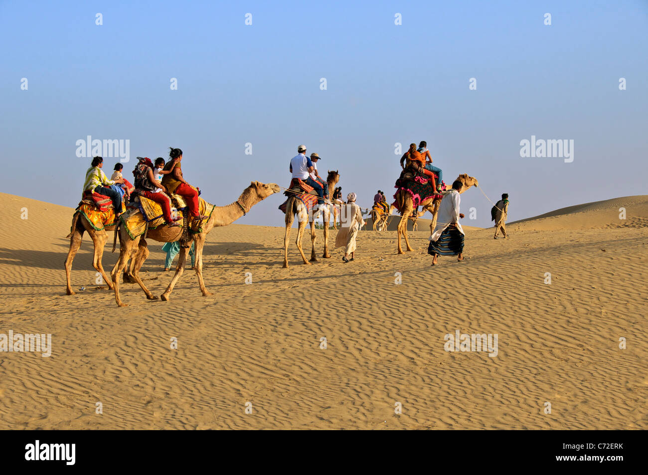 Indische Touristen, die mit dem Kamel Sam Dünen Desert National Park westlichen Rajasthan Indien Stockfoto