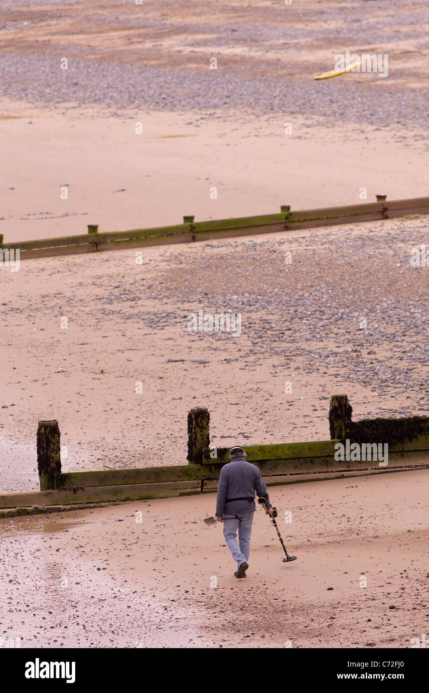 Ein Mann sucht den Strand von Cromer Norfolk mit Metall detecor Stockfoto