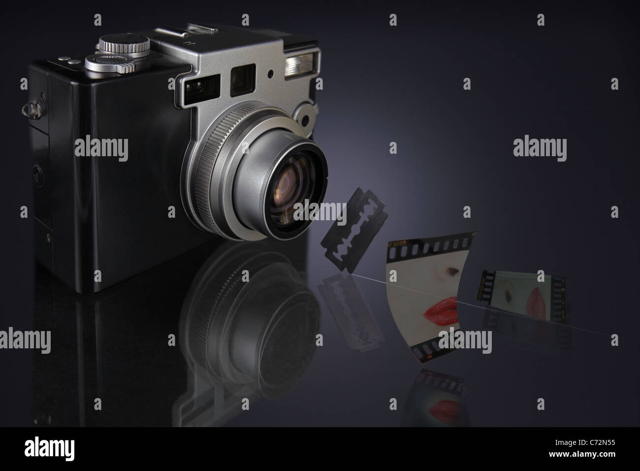 Kamera mit Objektiv fokussiert auf Rasierklinge hängen in der Luft und einer Rutsche scharf in zwei Stücke geschnitten Stockfoto