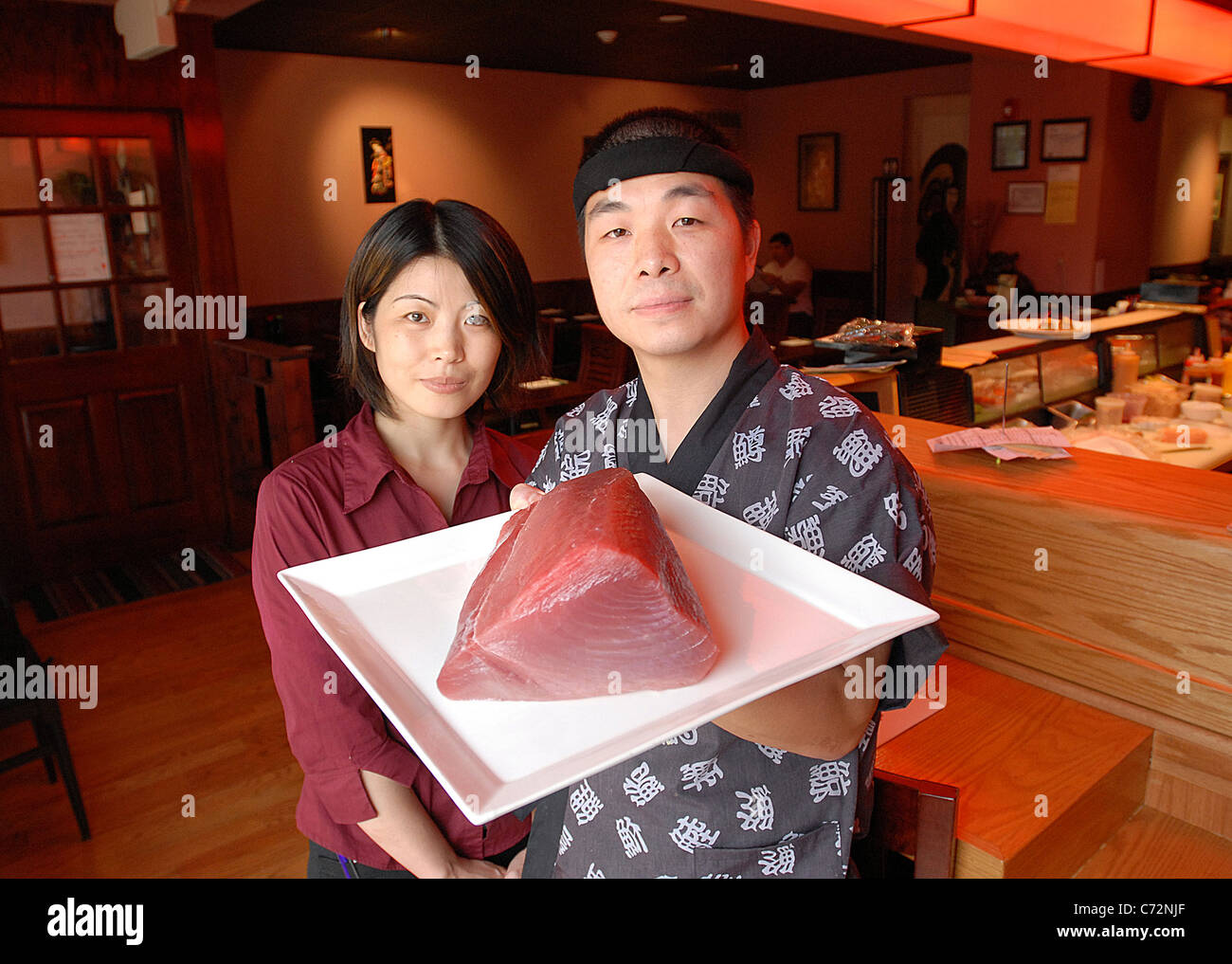 Connecticut USA Sushi-Restaurant-Besitzer mit großen Stück Thunfisch-Sashimi Stockfoto