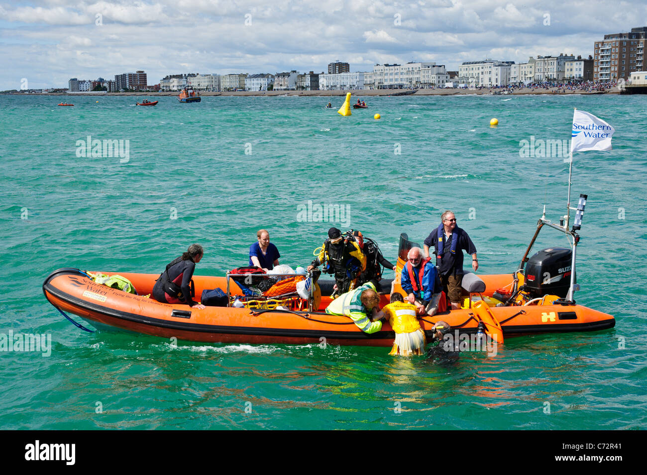 Eine Person wird in einem RIB Rescue Boot aus dem Meer gezogen. Stockfoto