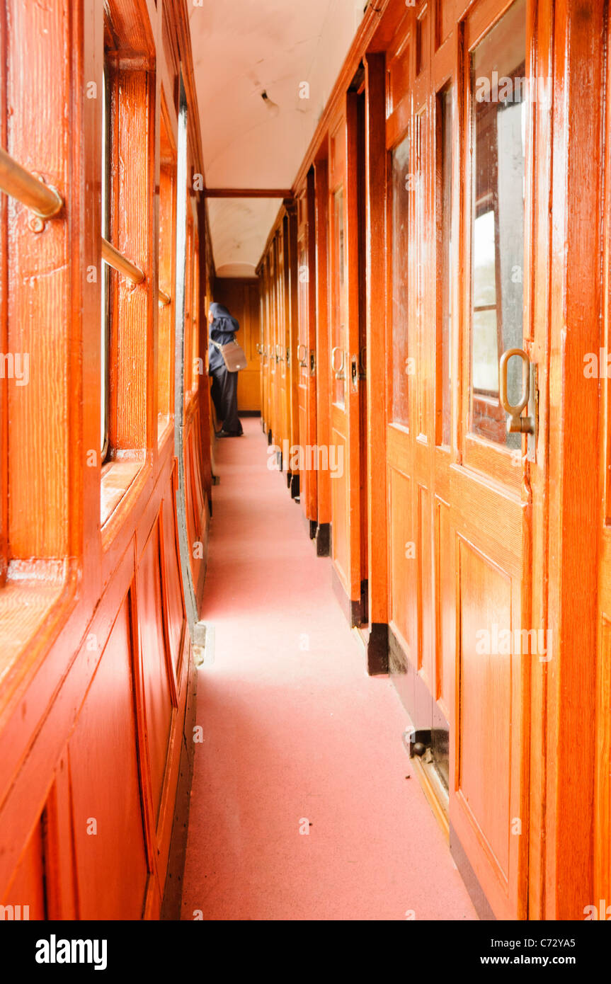 Dirigent stehen am Ende eines Korridors in einem altmodischen holzgetäfelten Eisenbahn Stockfoto