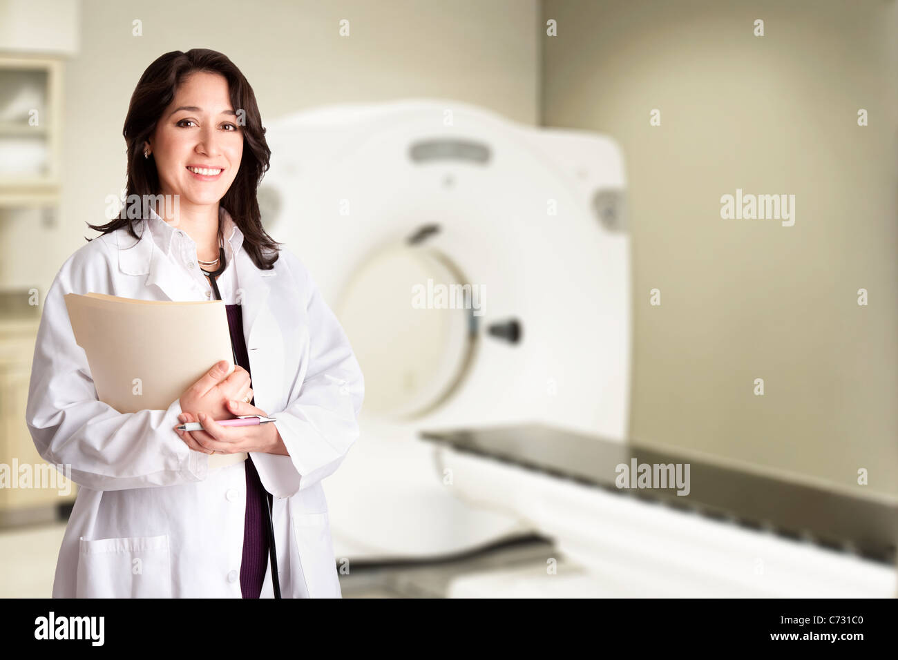 Doktor Arzt Radiologe hält medizinische Patientenakte und Stift stehend in CT-CAT-Scan-Zimmer im Krankenhaus. Stockfoto