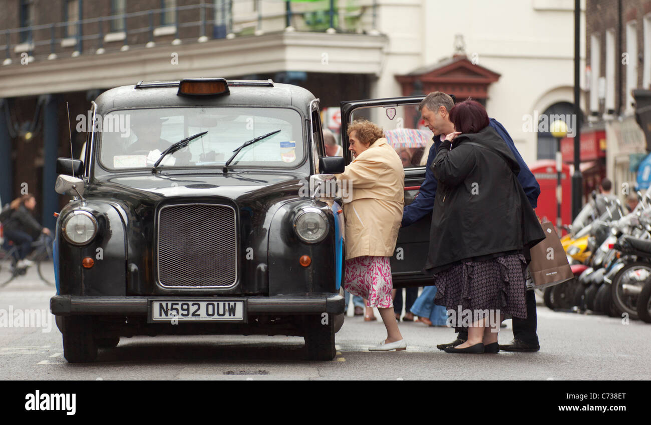 Leute steigen in ein London Taxi, Covent Garden, London. Stockfoto