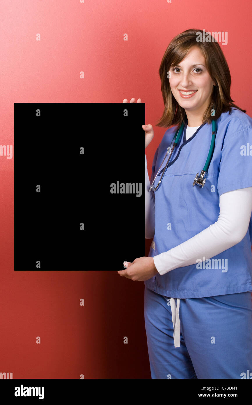 Ein junger Arzt hält ein schwarzer Schild mit Exemplar. Stockfoto