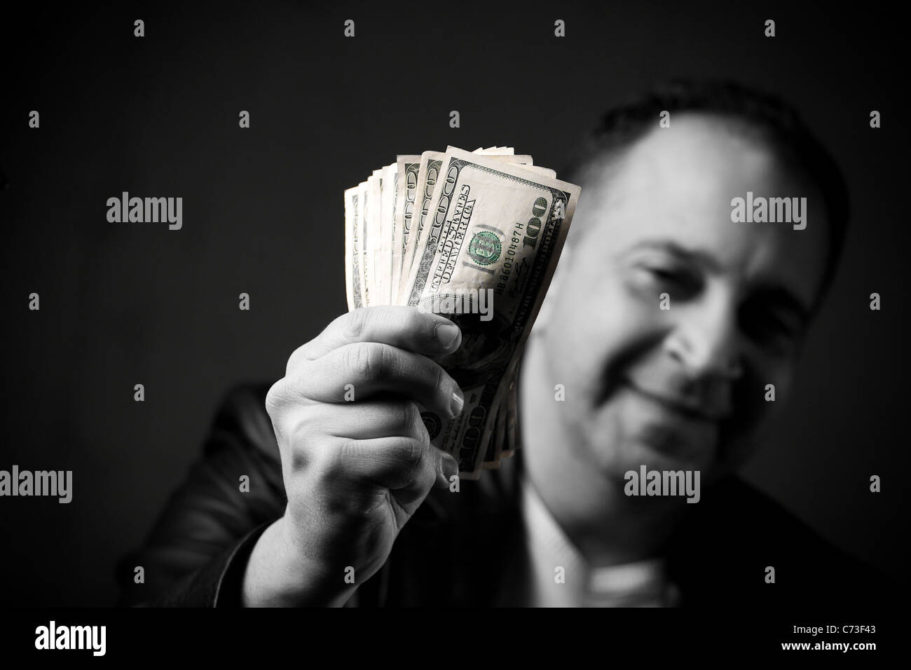 Ein glücklicher Mann hält eine Handvoll von Bargeld mit selektive Farbkorrektur. Stockfoto