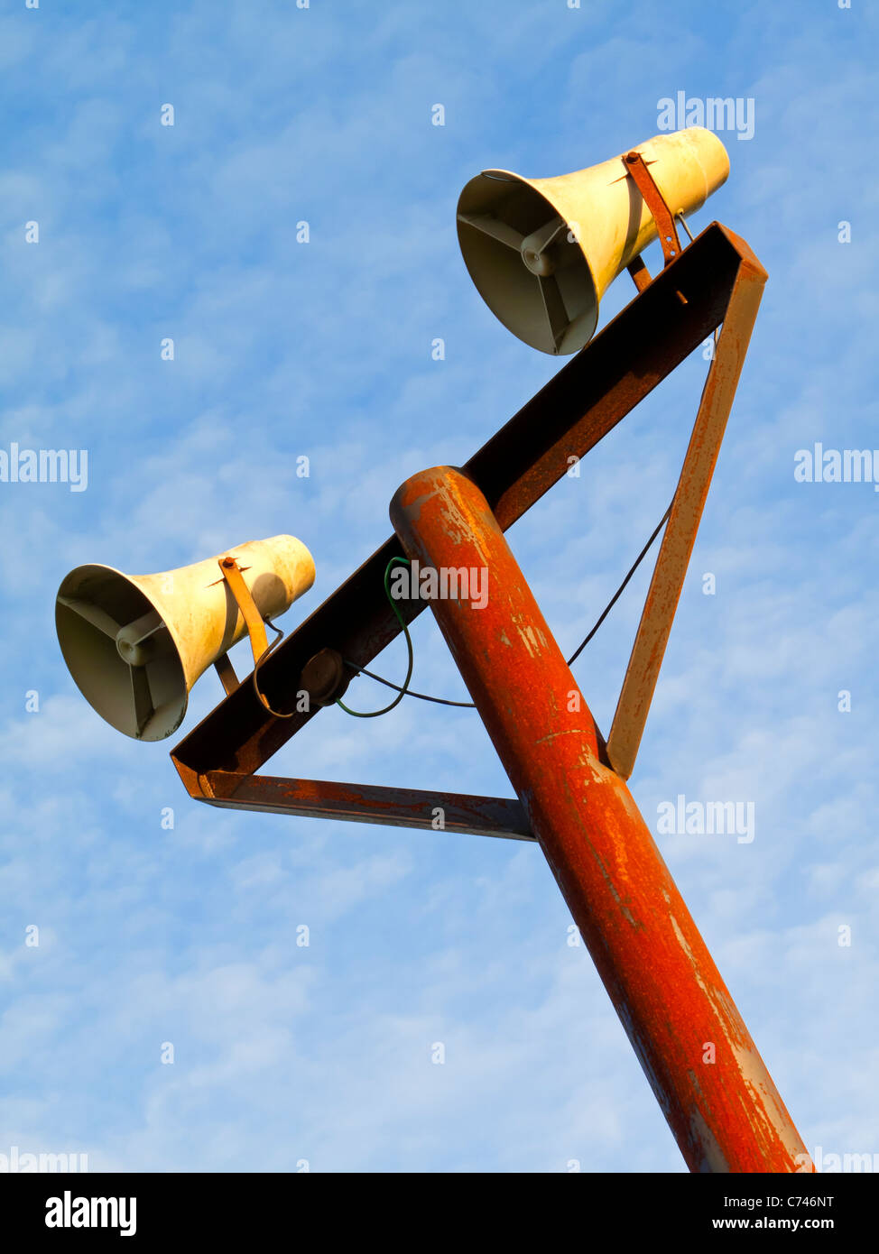 Paar von öffentlichen Adresse System Lautsprecher an einem Mast mit blauem Himmel hinter Stockfoto