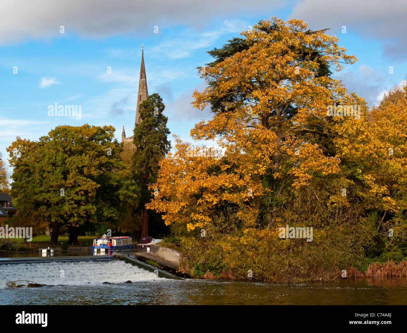 Der Fluss Avon in Stratford-upon-Avon Warwickshire England UK im Herbst mit Holy Trinity Church Turm sichtbar hinter den Bäumen Stockfoto