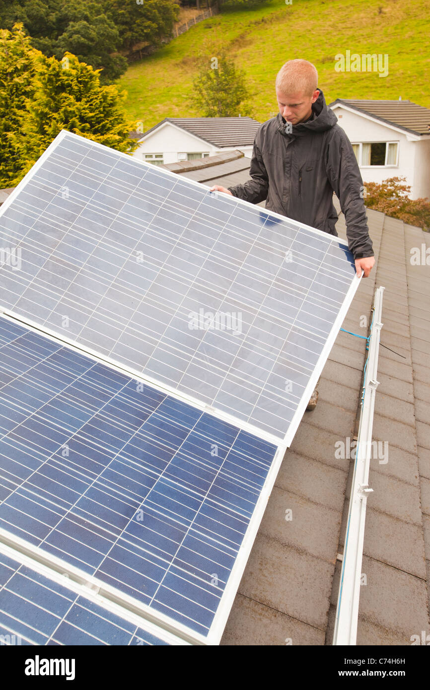 Arbeitnehmer, die Installation von solar-Elektro-Panels auf einem Hausdach in Ambleside, Großbritannien. Stockfoto
