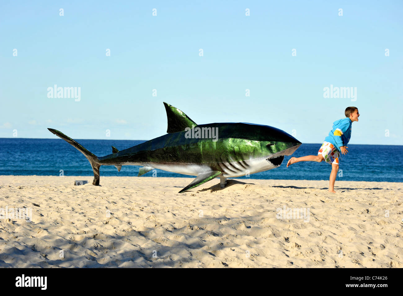 Ein Junge spielt mit einem plastischen Hai bei Currumbin Australia Stockfoto