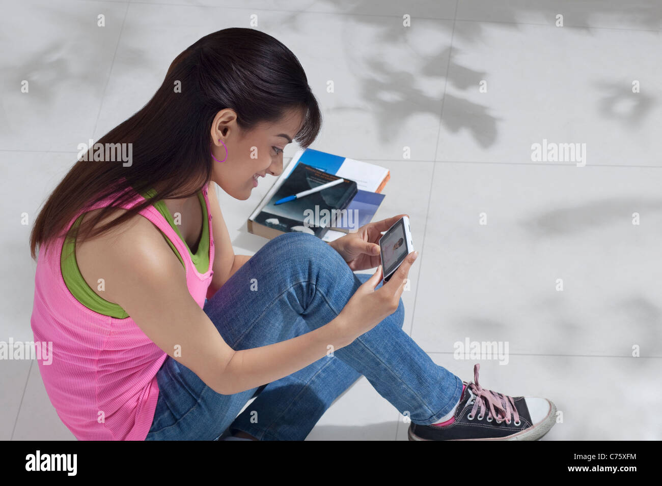 Erhöhte Ansicht von glücklich weibliche College-Student mit Handy Stockfoto